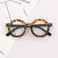 Classic round kids tortoise shell frame glasses with black temples on white background - Dark Leopard Clear Lens