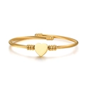 Golden stainless steel cable weave bracelet featuring a polished heart charm and beads - Gold