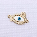 Macro detail of gold plated Evil Eye connector with blue enamel and clear zircon stones - White Gold Evil Eye