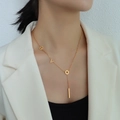 18k vergulde roestvrijstalen lariat ketting met geometrische bedels op witte blazer - Goud