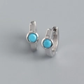 Macro view of S925 silver huggie earrings with round turquoise zircon stone inlay - 925 Silver / White Gold