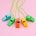 Colorful plastic whistles with lanyards in blue, green, orange, and yellow on pink background - Champion Whistle