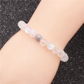 Bracciale di perle in pietra di luna con sfera di cristallo lucida sul polso - Traslucido