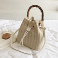 Beige straw bucket bag with bamboo handle and adjustable white shoulder strap - White