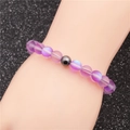 Bracelet de perles violettes givrées avec perle en métal gris sur poignet - Violet