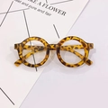 Detailed view of round tortoiseshell glasses frames on a minimalist background - Yellow Leopard Clear Lens