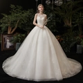 Elegante vestido de novia blanco tipo princesa con encaje y lentejuelas en entorno floral - US 26W / Largo al Suelo