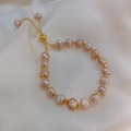 Detail of lavender freshwater pearls and gold beads on elegant white silk background - Pink Purple
