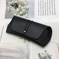 Detalle de funda para gafas en cuero negro granulado con cordón elástico y hebilla metal - Tipo de cordón / Negro (Cordón)