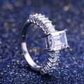Nahaufnahme eines Zirkonia-Rings mit Smaragdschliff auf blauem Sternenlicht-Hintergrund - US 8 / Silber