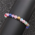 Bracciale di perle opache arcobaleno con ciondolo pavé dorato su un supporto da esposizione - Sfera di Zirconi a Fiore Dorato