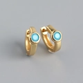 Macro shot of gold S925 silver huggie earrings featuring vibrant turquoise zircon stones - 925 Silver / Gold