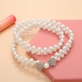 Elegant double-row pearl belt with a gold rhinestone bow accent on pink prop - Pearl Bowtie Gold