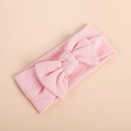 Detail of pink knitted baby headband with a large decorative bow and ribbed texture - Light Pink