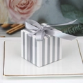 Gray and white striped square gift box with a satin ribbon bow on a white plate - Silver and White Stripes + Silver Ribbon