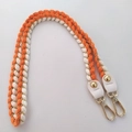 Close-up of woven orange and white shoulder strap with gold metal hooks and leather tabs - 80cm / Orange