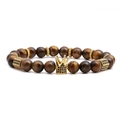Macro detail of tiger eye stone beads with a gold crown charm inlaid with black zircons - Elastic Beaded Style / Tiger's Eye