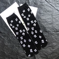 Detail shot of black Tabi socks featuring white cross patterns and ribbed cuffs - 35-41 / Black Flower