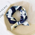 Donkerblauwe zijden sjaal met abstract bloemmotief gepresenteerd op een beige dienblad - Witte magnolia