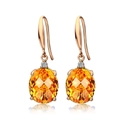 Elegante gouden oorbellen met ovale oranje edelstenen en kleine diamantaccenten - Oorbellen