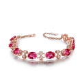 Bracciale in oro rosa con pietre rosa ovali e maglie a quadrifoglio su fondo bianco - Bracciale