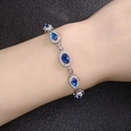 Elegante zilveren armband met druppelvormige blauwe edelstenen en kristallen om de pols - Blauwe Steen Witgoud
