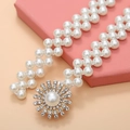 Detail view of pearl and rhinestone floral buckle on elastic gold chain belt - Flower