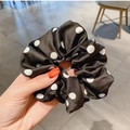 Elastico per capelli in raso a pois bianchi e neri mostrato a mano per uno stile unico - Polka Dot Nero