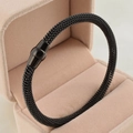 Dettaglio macro del bracciale a cavo in maglia nera con chiusura magnetica su velluto - Nero