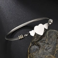 Zilveren roestvrijstalen kabelarmband met drie onderling verbonden hartbedels - Driedubbel Hart / Staalkleur