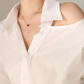 Elegante zilveren ketting met een rode hartvormige hanger gedragen door een vrouwelijk model - 40+5cm / Staalkleur