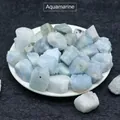 Natural raw aquamarine crystal stones in a white bowl on dark textured background - Aquamarine