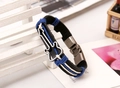 Detail eines Vintage Lederarmbands mit Gitarren-Metallanhänger und Druckknopfverschluss - Schwarzes Herrenmodell