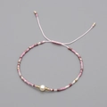 Handmade beaded bracelet with pink, purple, white beads and a central natural pearl - Pink Purple