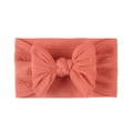 Close-up of soft jacquard nylon baby headband with a large coral pink bow knot - Watermelon red