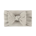 Detail of beige jacquard nylon baby headband featuring cable knit texture and large bow - Gray