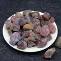Natural tourmaline raw stone chips in assorted colors on a white ceramic plate - Tourmaline