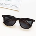 Detalle de gafas de sol rectangulares negras con remaches plateados sobre fondo blanco - Negro y Gris