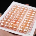 Close-up of high-luster pink freshwater button pearls displayed on a white card mount - 4.0-4.5mm (200pcs/Card) / Orange Pink