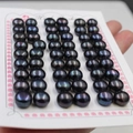 Macro shot of loose black freshwater pearls with iridescent luster on display card - 4.0-4.5mm (200pcs/Card) / Black