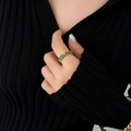 18K gold plated ring with green baguette-cut cubic zirconia on a model's finger - Size 8 Adjustable / Gold/Green