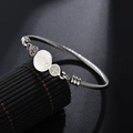 Silver stainless steel twisted cable bangle featuring three Saint Benedict religious medals - St. Benedict Medal / Steel