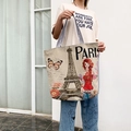 Ethnic canvas tote bag with French Paris print and black striped handles on a model - Eiffel Tower & Lady