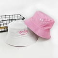 Close-up of white and pink cotton bucket hats with high-quality smile embroidery detail - Pink