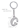 Detailed view of silver letter G keychain with sparkling rhinestones and metal ring - Letter G