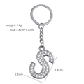 Macro detail of silver-tone letter S keychain with sparkling rhinestones and measurements - S