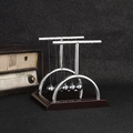 Newton's cradle with wooden base and five silver metal balls on a dark desk - Medium T-Shape