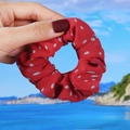 Détail d'un chouchou en mousseline rouge à pois blancs tenu devant un paysage de bord de mer - 3# Chouchou Rouge Poupée
