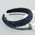 Detailed close-up of navy blue baroque headband with sparkling faceted beads on light grey stand - Navy Blue