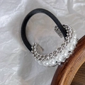 Macro view of elastic hair tie with silver alloy chain and elegant white pearls decoration - Silver